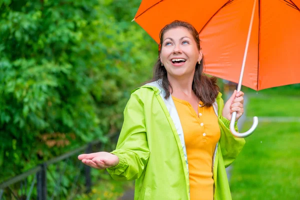 Heureuse jeune femme avec un parapluie lumineux attendant la fin rai — Photo