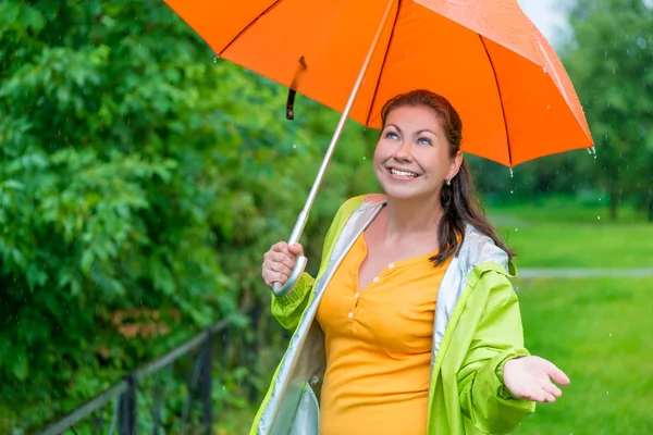 Beautiful girl with a bright orange umbrella — Stock Photo, Image