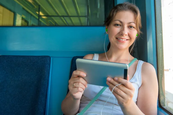 Roztomilá brunetka s tabletem sedí v metru — Stock fotografie