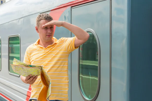 30-year-old man with a map in hand looking into the distance — Stock Photo, Image