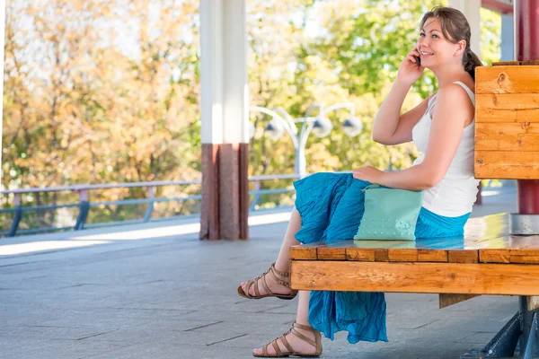 Joven y hermosa mujer habla por teléfono esperando el tra — Foto de Stock