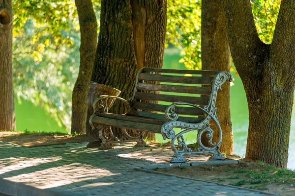 Weergave van de lege Bank in het park van de zomer in de buurt van het meer — Stockfoto