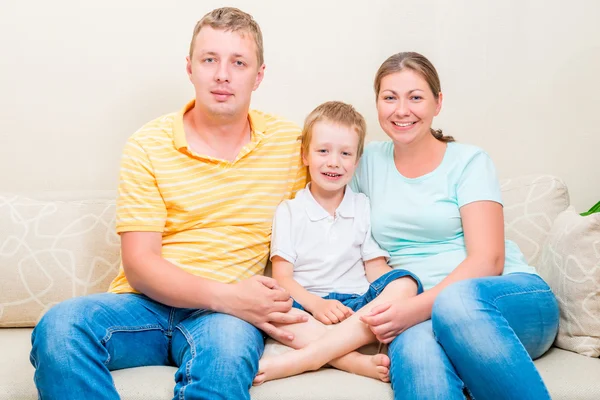 Porträtt av en lycklig familj i soffan i vardagsrummet — Stockfoto