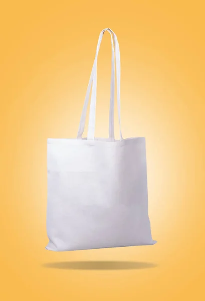 Blank White tote bag canvas for shopping. on yellow background.