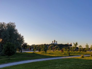 Yaroslavl Strelka 'sında aydınlık bir yaz akşamı Yaroslavl' da Volga ve Kotorosl 'un seti üzerindeki parkın güzel peyzajı. Varsayım katedrali. Gün batımı sahnesi