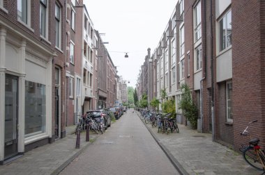 AMSTERDAM, NETHERLANDS. Haziran 06, 2021. Tipik Hollandalı evleriyle Amsterdam 'ın güzel manzarası. Sokakta bisikletler.