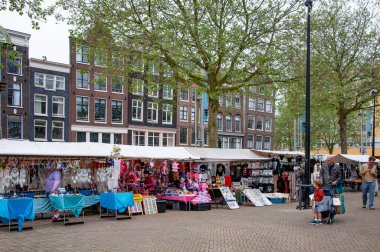 AMSTERDAM, NETHERLANDS. Haziran 06, 2021. Tipik Hollandalı evleriyle Amsterdam 'ın güzel manzarası. Adil, meydanda pazar