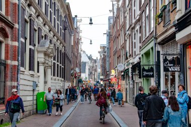 AMSTERDAM, NETHERLANDS. Haziran 06, 2021. Tipik Hollandalı evleriyle Amsterdam 'ın güzel manzarası. Sokaktan alışveriş yapıyor..