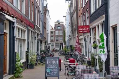 AMSTERDAM, NETHERLANDS. Haziran 06, 2021. Tipik Hollandalı evleriyle Amsterdam 'ın güzel manzarası. Sokaktaki küçük restoranlar..