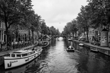 AMSTERDAM, NETHERLANDS. Haziran 06, 2021. Tipik Hollandalı evleri, köprüleri ve Chanel 'i olan Amsterdam' ın güzel manzarası. Barajdaki küçük tekneler. Siyah beyaz fotoğraf.
