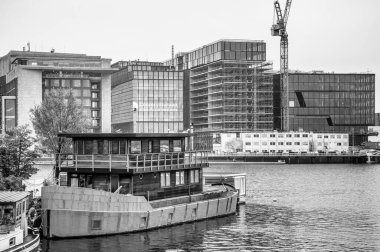 AMSTERDAM, NETHERLANDS. Haziran 06, 2021. Bir nakliye kanalı ve köprüler için güzel bir manzara. Siyah beyaz fotoğrafçılık. Limanda küçük tekneler, gemiler ve mavnalar var. Siyah beyaz fotoğraf..