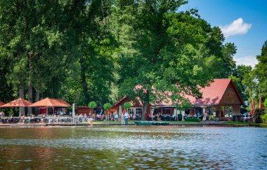 Harcama, Almanca. 20 Haziran 2021 'de. Hoocker Mağribi Çiftliği. Göl manzarası, setin üzerindeki kafede dinlenen insanlar..