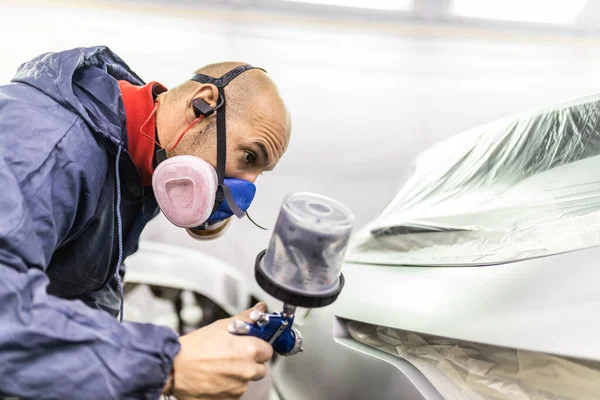 若い大人の男性の車画家が工房の塗装ブースで車を描き — ストック写真