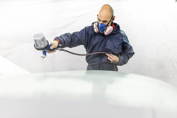 若い大人の男性の車画家が工房の塗装ブースで車を描き — ストック写真