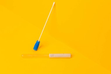 Sarı arkaplanda Covid-19 için örnek testi gösteriliyor