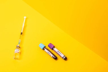 Aşıyla Coronavirus ilerlemesi, pozitif ve negatif testler. Sarı arka plan. Yüksek açı.