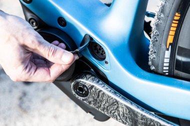 unrecognizable man showing the charging port of his e-bike or electric bike