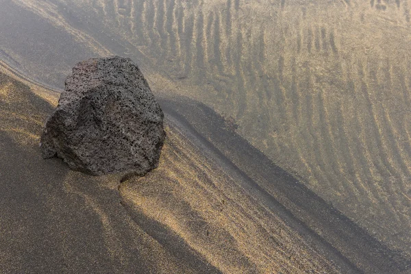 Вулканічний камінь і пісок у воді — стокове фото