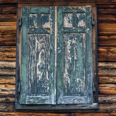 Ahşap kulübede eski kapalı yeşil ve ahşap panjurlar.