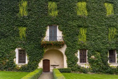 Brixen, İtalya - 9 Ekim 2020: Dolomites, İtalya 'da sonbaharda Abbazia di Novacella, Kloster Neustift manastırında yeşil dağcı ve sarmaşıklı bir ev.
