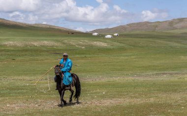 Baruuntunuun, Moğolistan - 8 Ağustos 2019: Moğolistan 'da at sırtında, tepelerde ve dağlarda çobanlı Steppe.