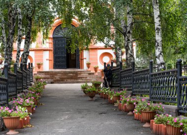 Irkutsk, Rusya - 6 Eylül 2019: Kilisenin önünde çiçekli Rus Ortodoks Kresto Vozdvizhenskaya Kilisesi.