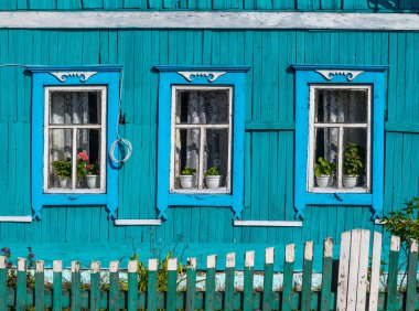 Rusya 'nın eski mavi kulübesi, yeşil çitli ve Tinskoy, Sibirya, Rusya' da çiçekler var..