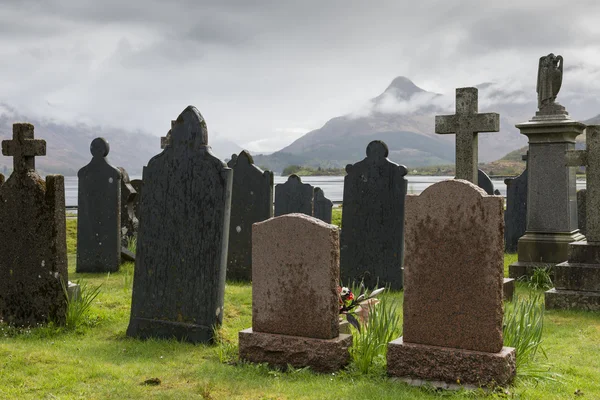 Gravplass Ballachulish med fjell – stockfoto