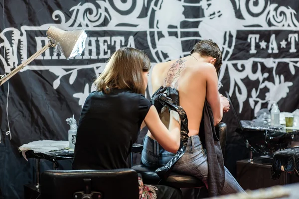 Showing process of making a tattoo by professional girl artist in studio. Tattooist design in pattern dream catcher. Art on human body skin. Machine gun. Sexy woman concept. White and black ink. — Stock Photo, Image