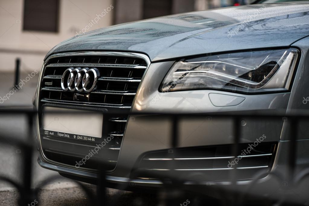 The emblem on the front grille of a luxury Audi sedan on city street
