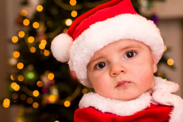 Un enfant déguisé en Père Noël sous l'arbre — Photo