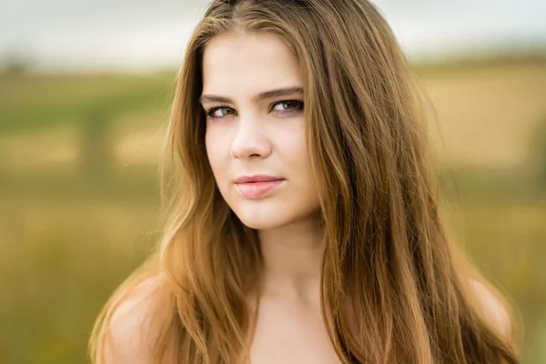 Retrato de una hermosa chica en un campo — Foto de Stock