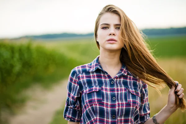 Retrato de una hermosa chica en un campo — Foto de Stock