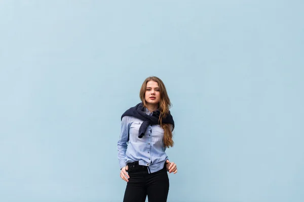 Mooi meisje op een achtergrond van blauwe muur — Stockfoto