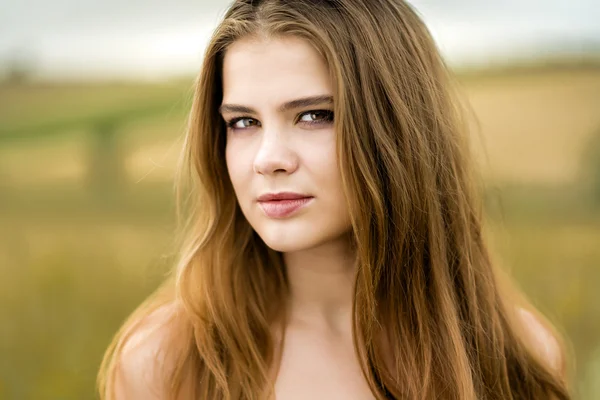 Retrato de una hermosa chica en un campo — Foto de Stock