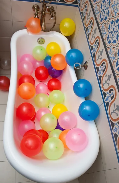 Bunch of colorful balloons in bath tube. Large pile of multicolored inflated balloons. — Stock Photo, Image