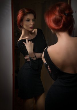 Siyah elbise büyük duvar ayna önünde poz ile çekici seksi redhead. Onu geri açığa Kızıl saçlı şehvetli genç kadın portresi. Yaratıcı saç modeli, yansıma fotoğraf ile güzel kız