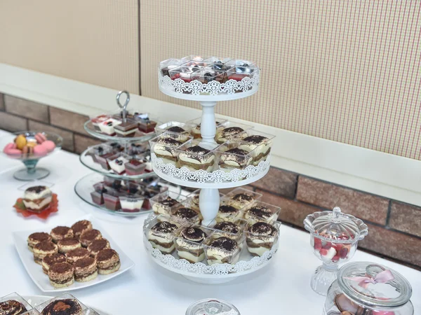 Dekoracja ślubu z pastelowe kolorowe babeczki, bezy, babeczki i macarons. elegancki i luksusowy zdarzenia układ z kolorowe makaroniki. deser ślubu z macaroons — Zdjęcie stockowe