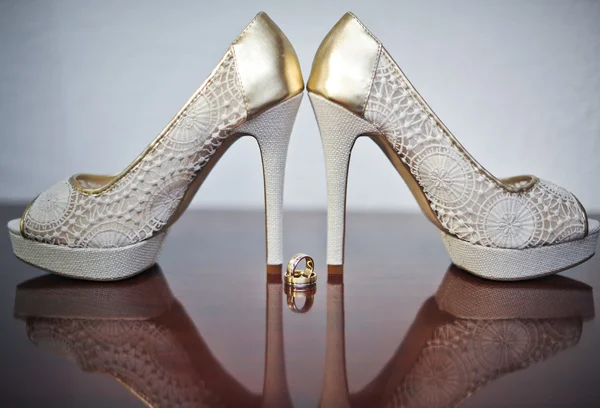 High heels wedding shoes and rings on table. Wedding accessories. — Stock Photo, Image