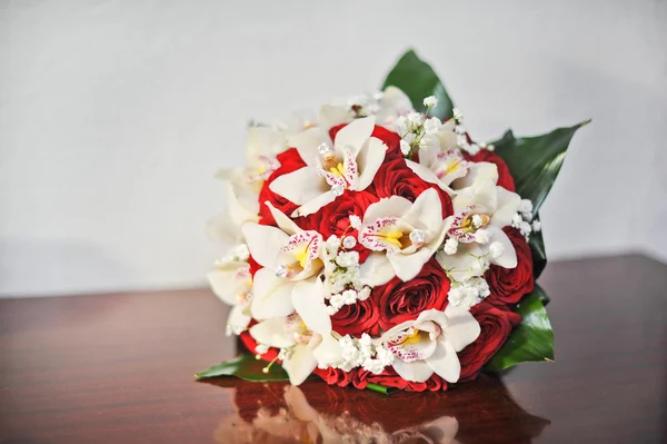 Hermoso ramo de flores de rosas, en la mesa. Ramo de boda de rosas rojas. Elegante ramo de bodas en la mesa en el restaurante — Foto de Stock