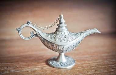 Antik Alaaddin'in sihirli lambası. ahşap masa üzerinde gümüş cin lamba. eski stil kandil