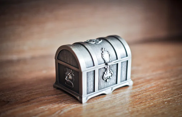 Vieux coffre en argent isolé sur une table en bois. Cercueil métallique rétro fermé. Boîte vintage bijoux . — Photo