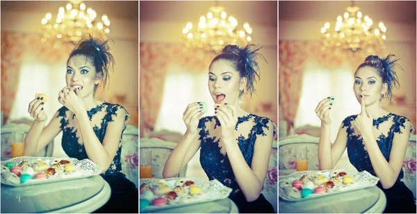 Μοντέρνα, ελκυστική νεαρή γυναίκα στο μαύρο φόρεμα που τρώει macaroons στο εστιατόριο. όμορφη μελαχρινή κρατώντας τα cookies σε κομψό σκηνικό εκλεκτής ποιότητας. ελκυστική γυναίκα με δημιουργική κούρεμα τρώγοντας πολλά κέικ — Φωτογραφία Αρχείου