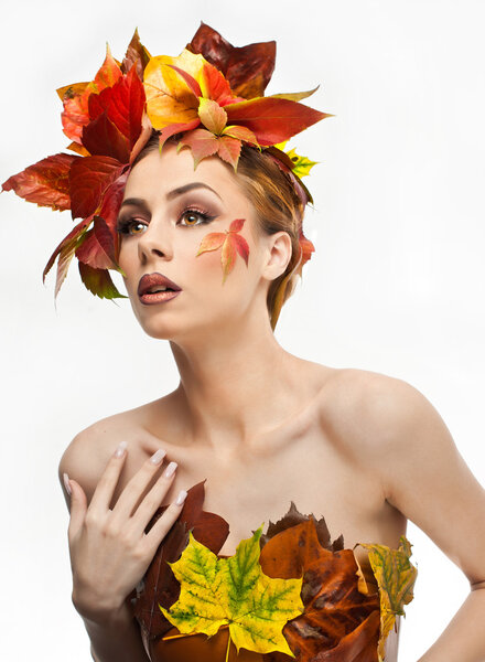 Autumnal woman.  Beautiful creative makeup and hair style in fall concept studio shot. Beauty fashion model girl with autumnal make up and hair style. Fall. Creative Autumn makeup. Gorgeous redhead.
