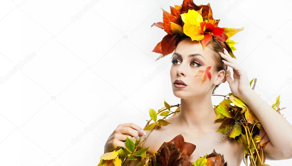 Autumnal woman.  Beautiful creative makeup and hair style in fall concept studio shot. Beauty fashion model girl with autumnal make up and hair style. Fall. Creative Autumn makeup. Gorgeous redhead.