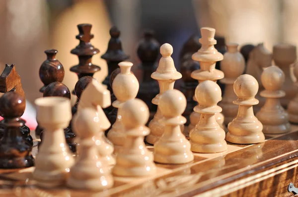 Piezas de ajedrez en blanco y negro en un tablero de ajedrez, primer plano. Conjunto de figuras de ajedrez en el tablero de juego —  Fotos de Stock