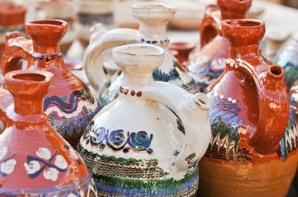 Romanian traditional pottery handcrafted mugs at a souvenir shop. Romanian traditional handcrafted pottery jugs to be sold at the market — Stock Photo, Image