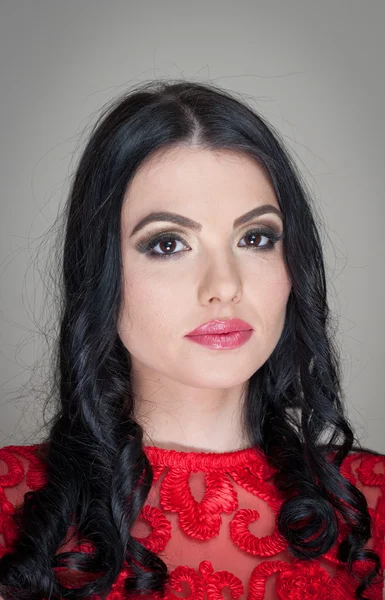 Kapsel en make-up - mooie vrouwelijke kunst portret met mooie ogen. Elegantie. Echte natuurlijke lange haren brunette in studio. Portret van een aantrekkelijke vrouw met rode lippen in rode kant blouse — Stockfoto