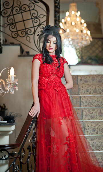 Красивая девушка в длинном красном платье позирует в винтажной сцене. Молодая красивая женщина в красном платье в старом отеле. Чувственная элегантная молодая женщина в красном длинном платье крытый выстрел
.