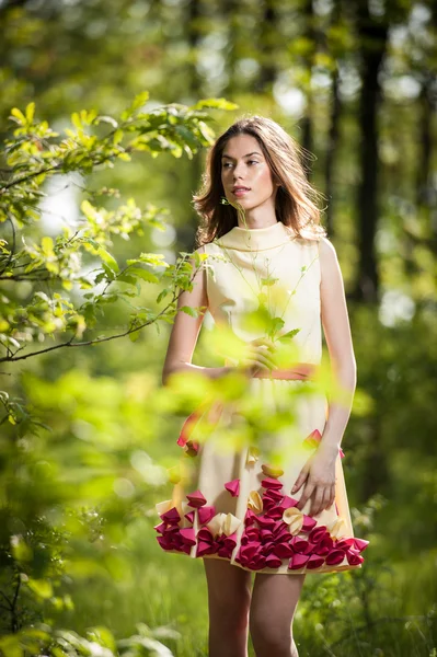 森の中で黄色のドレスで美しい少女妖精の森林でロマンチックな女性の肖像画。夏の草原、屋外撮影で見事なファッショナブルな 10 代のモデル。かわいいブルネットのロングヘアー女性. — ストック写真